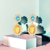Golden flower-shaped earrings set with blue and yellow bicolor gemstones Application Scenario